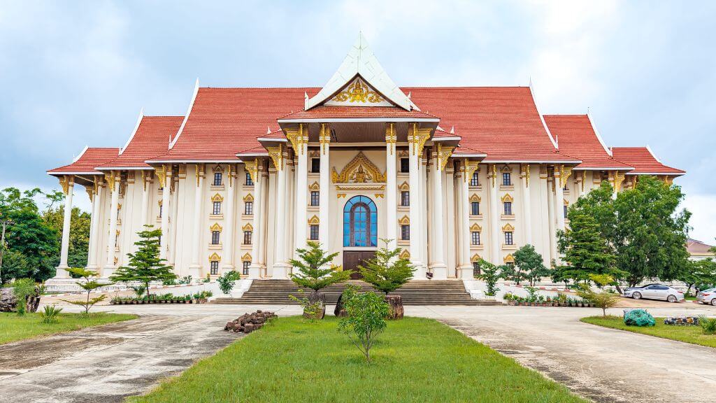 Tòa nhà màu vàng kem nổi bật giữa khuôn viên rộng, mang kiến trúc kết hợp Pháp – Lào độc đáo